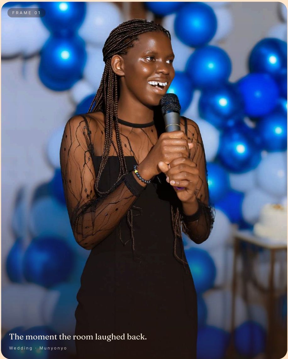 Nebaza Grace holding a microphone, smiling at a Munyonyo wedding with blue balloon backdrop